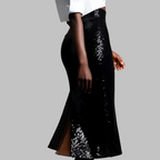 Black sequin skirt with a white top on a gray background