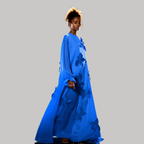 Woman wearing a blue dress with floral patterns on a gray background