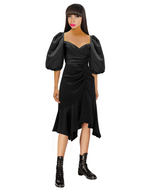 Woman wearing a black dress with puffed sleeves on a white background