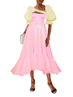 Woman wearing a pink dress with a yellow top on a white background