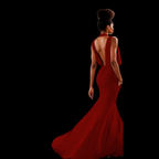 Woman in a red evening gown with a long train on a black background