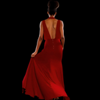 Woman wearing a red dress with an open back on a black background