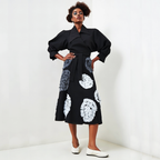 Woman wearing a black coat with floral patterns on a white background