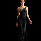 Woman wearing a black evening gown with a silver embellishment on a black background
