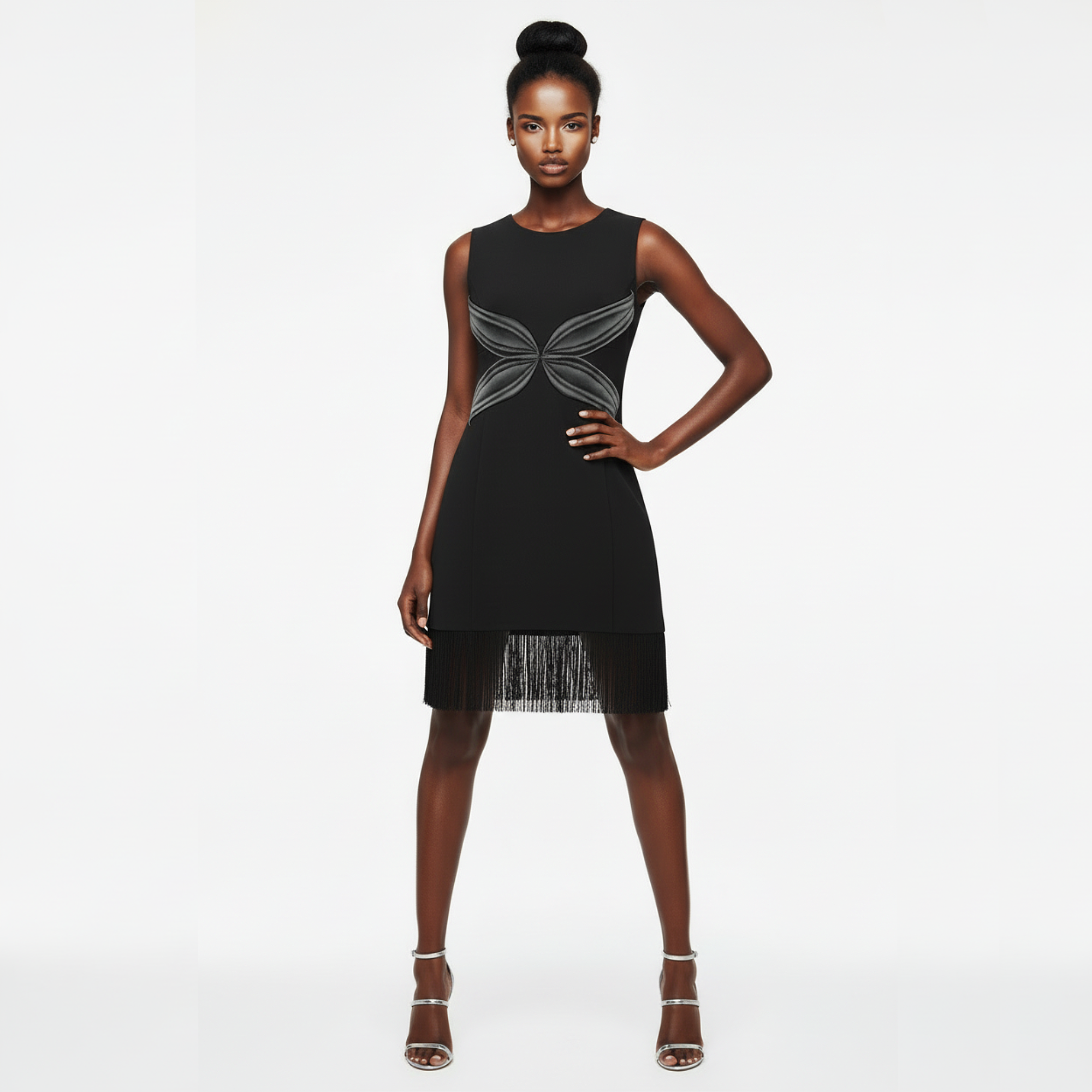 Black dress with silver detailing worn by a model on a white background
