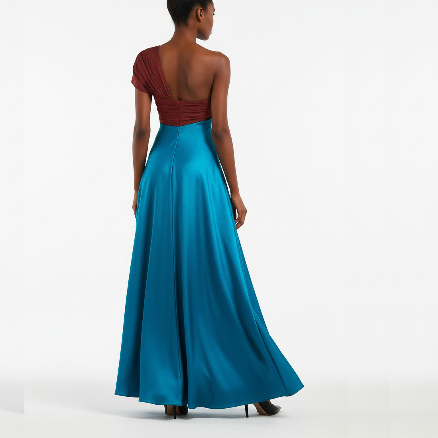 Woman wearing a one-shoulder red top and long blue dress on a white background