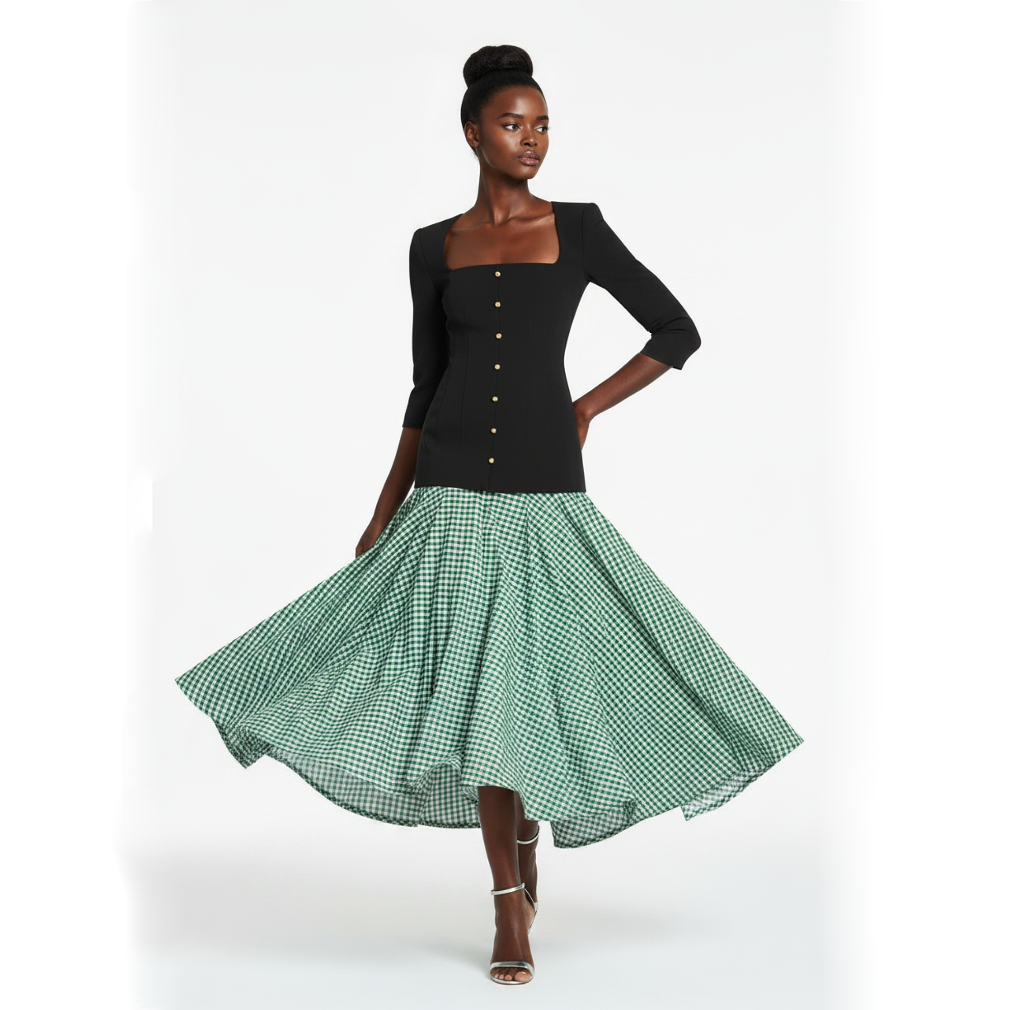 Woman wearing a black top and green checkered skirt on a white background