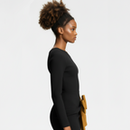 Woman in a black outfit holding a wooden object against a white background