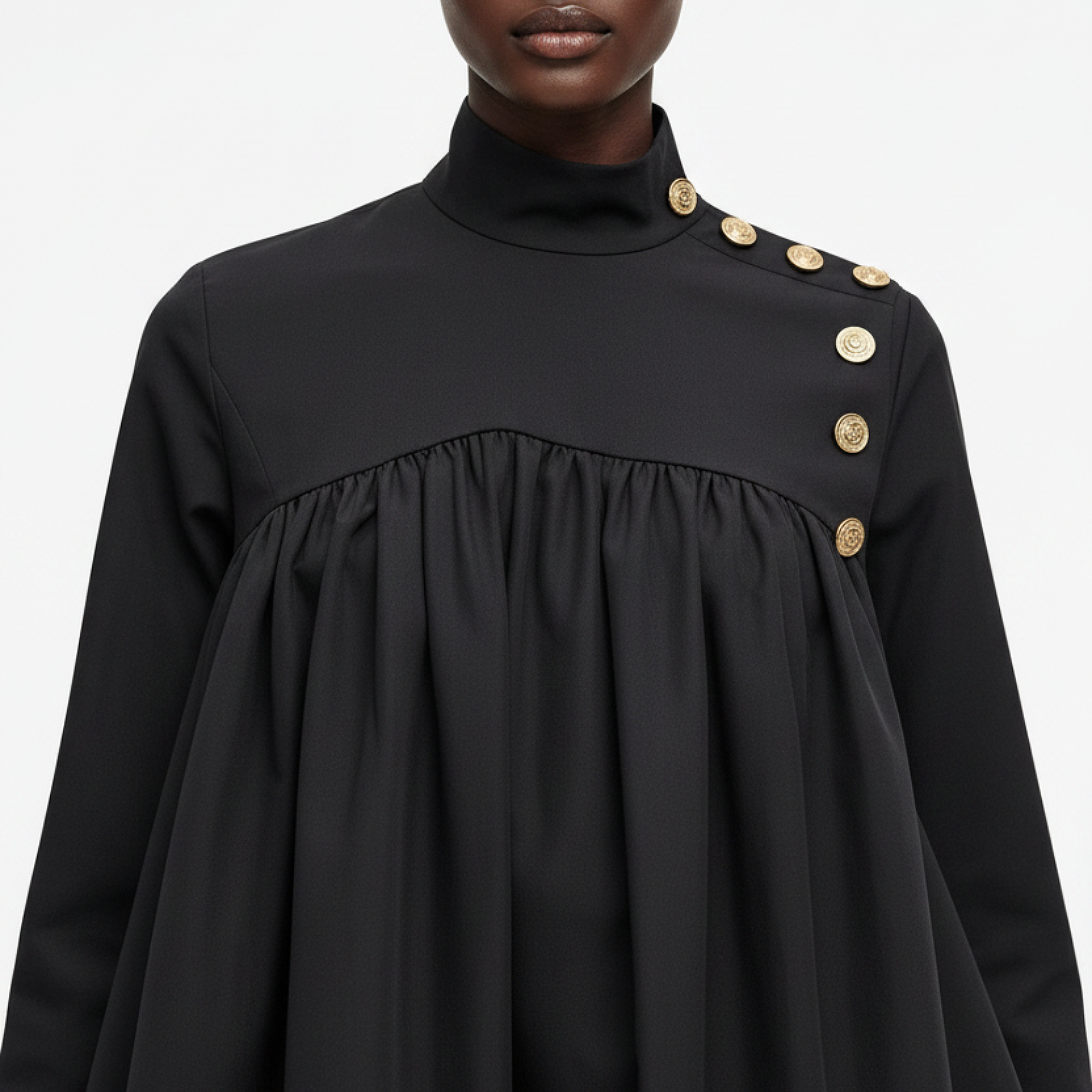 Black dress with gold buttons on a plain background