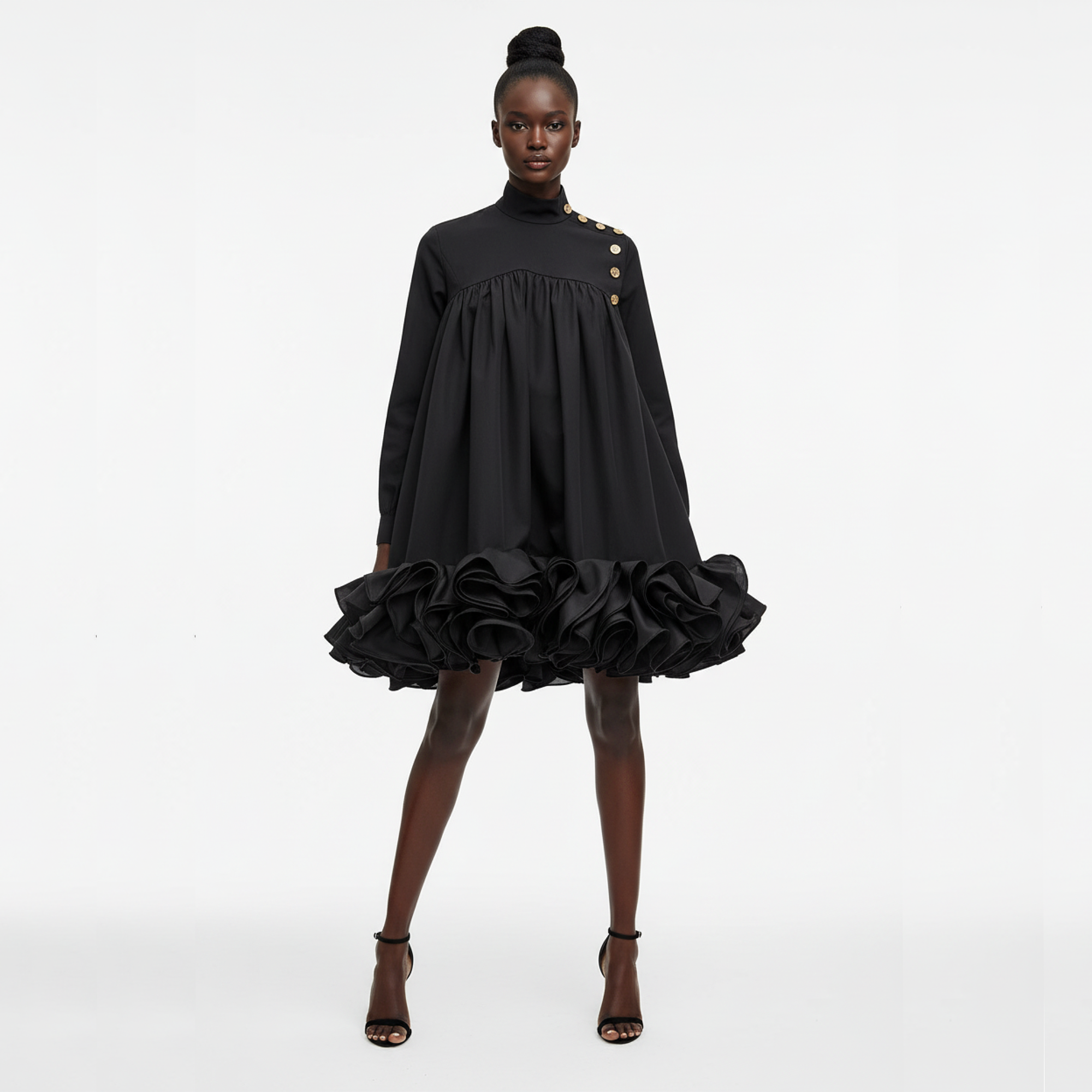 Black dress with ruffled skirt worn by a model on a white background