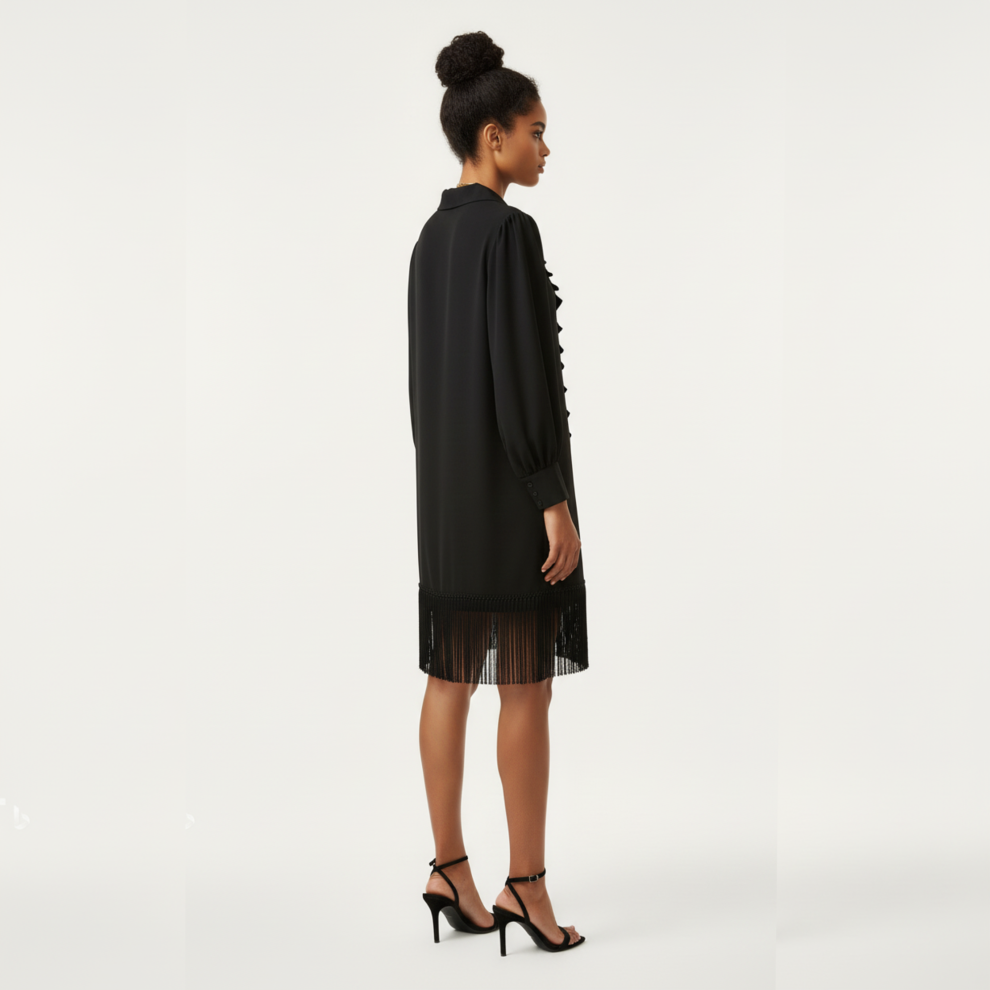 Woman wearing a black dress with sheer overlay on a white background