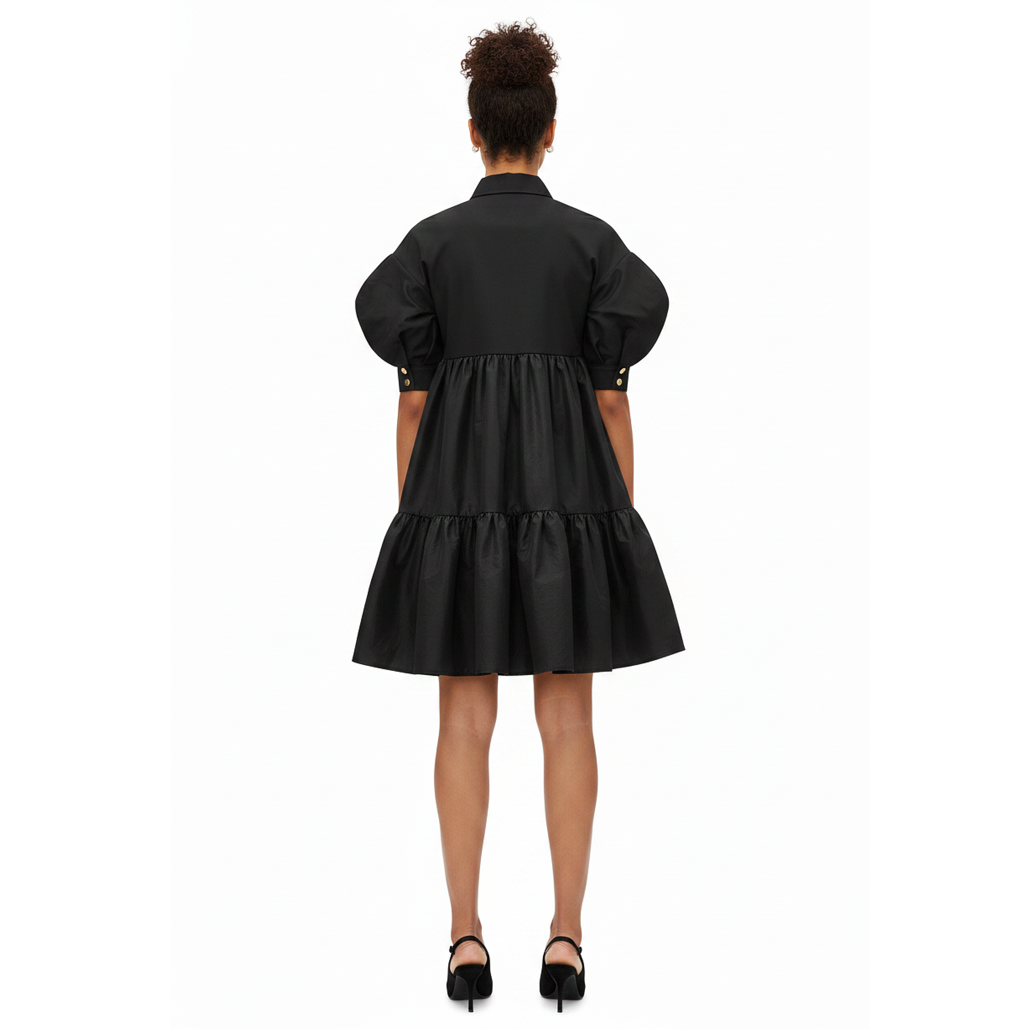 Black dress worn by a model on a white background