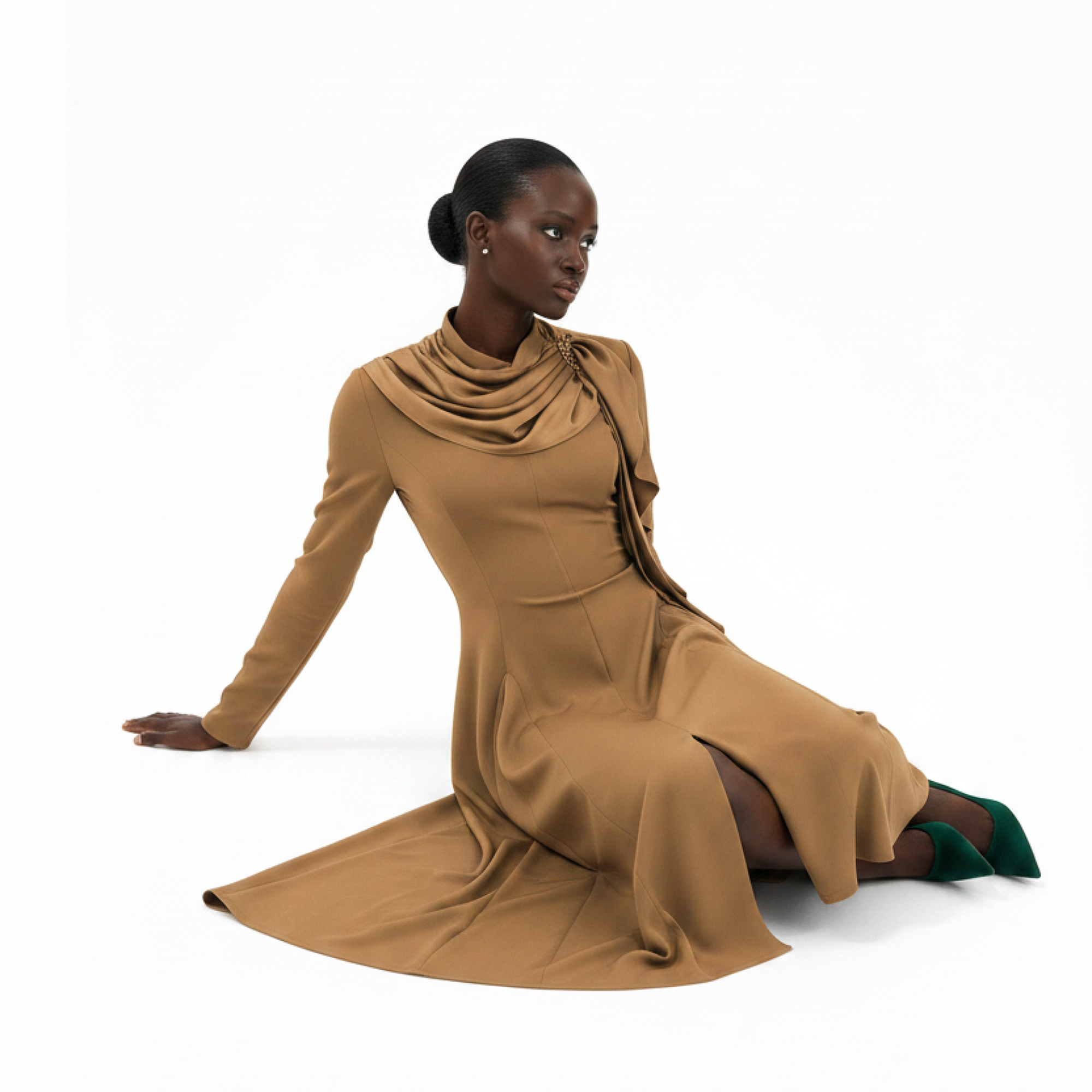 Woman wearing a brown dress sitting on a white background