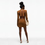 Woman wearing a brown dress with cut-out back design on a white background