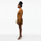 Woman in a brown suit standing against a white background