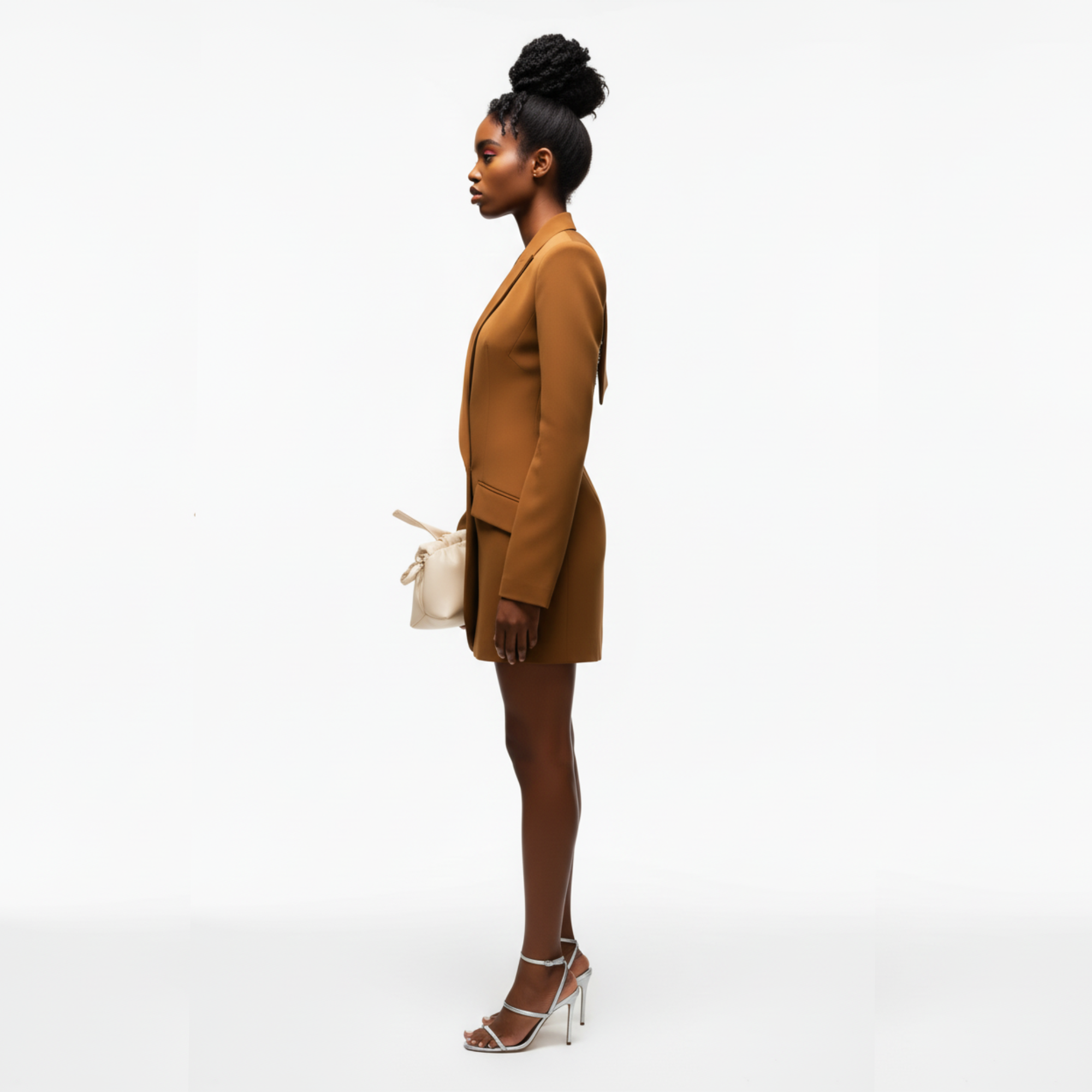 Woman in a brown suit standing against a white background