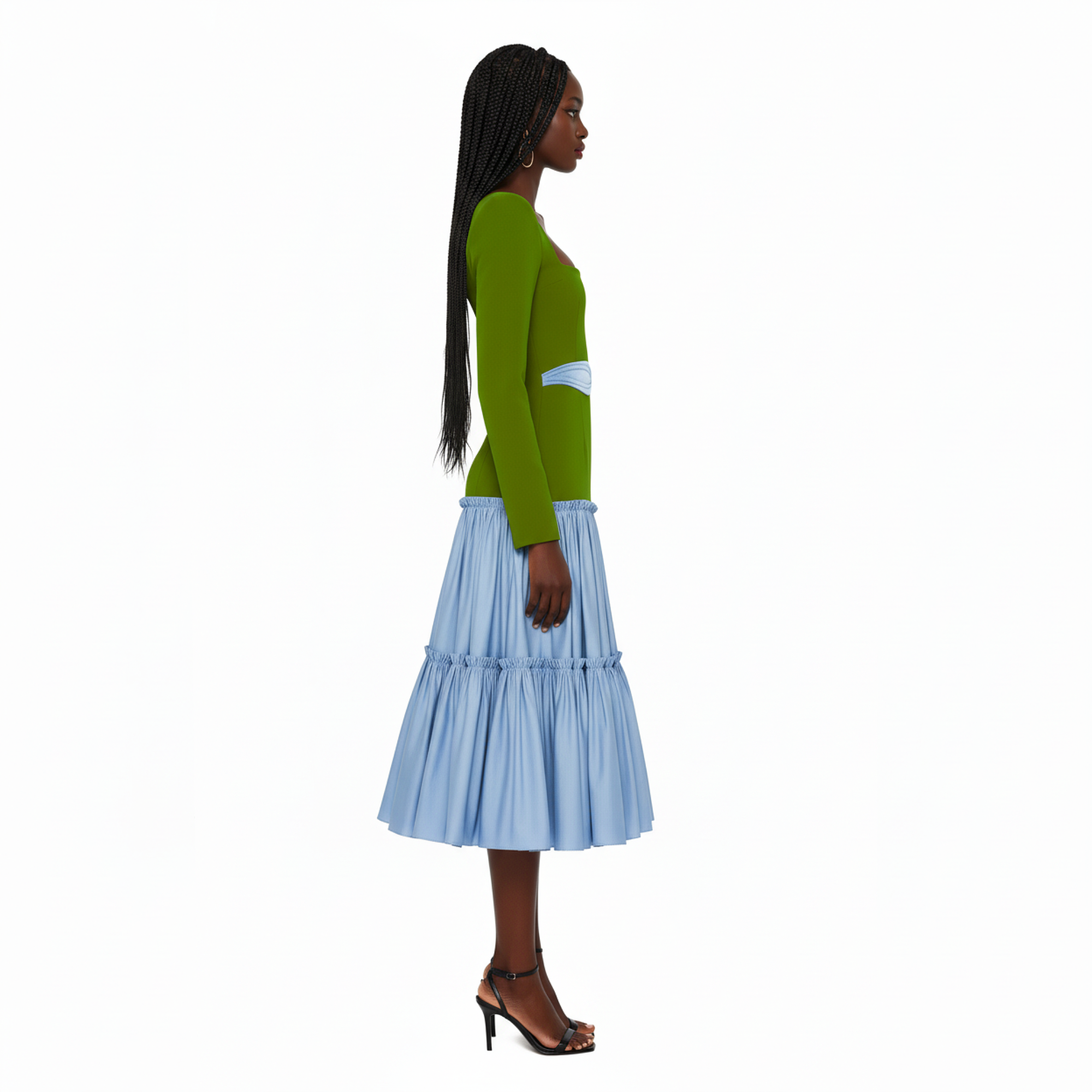 Woman wearing a green top and light blue tiered skirt on a white background