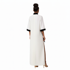 Woman wearing a white dress with black trim on a white background