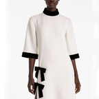 White dress with black accents and bows on a white background