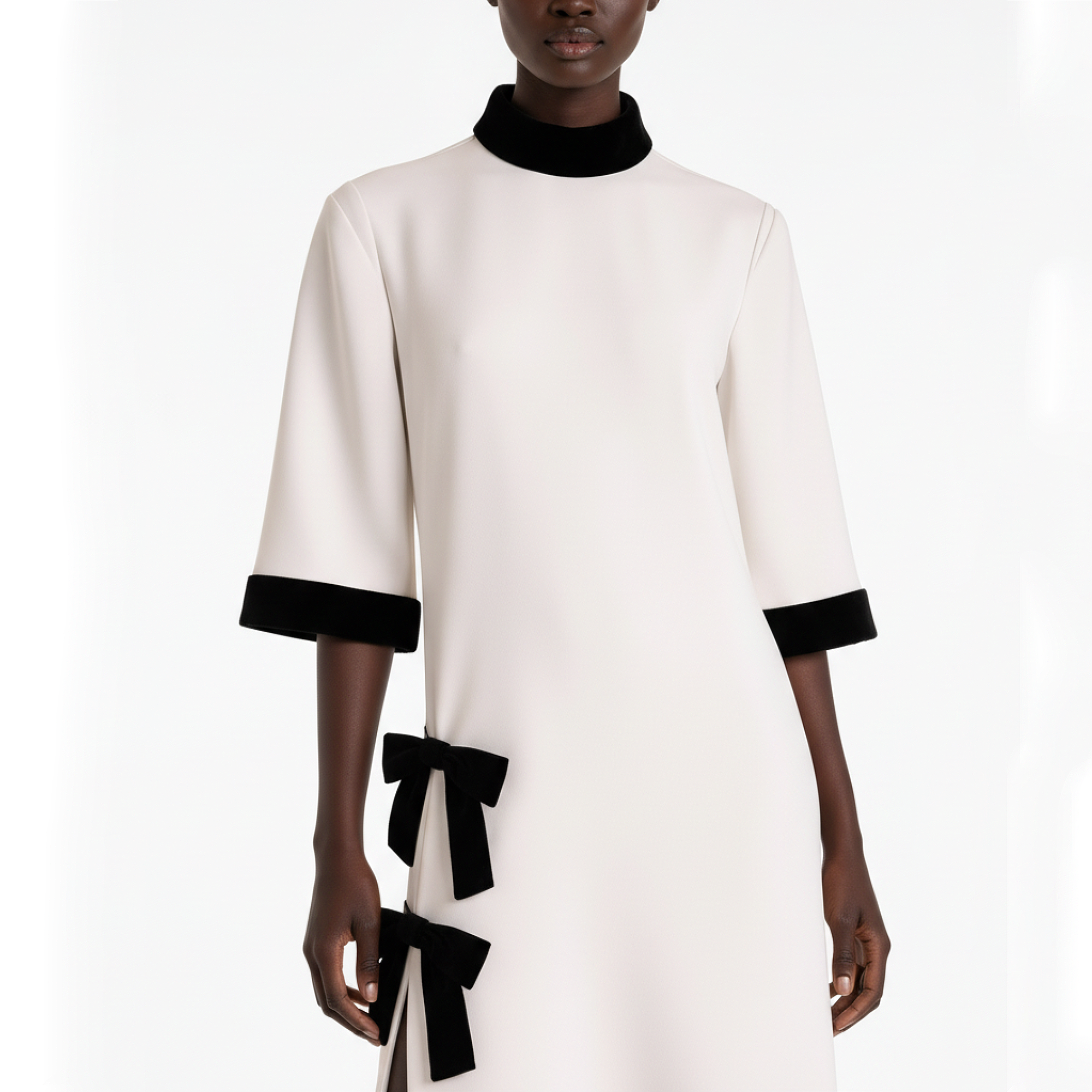 White dress with black accents and bows on a white background