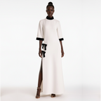 Woman wearing a white dress with black accents on a white background