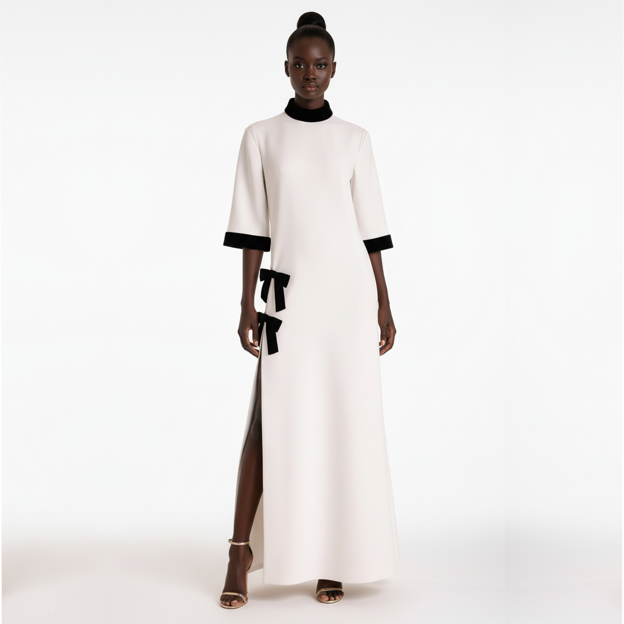 Woman wearing a white dress with black accents on a white background