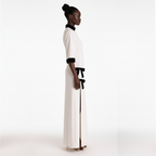 Woman wearing a white dress with black accents on a white background