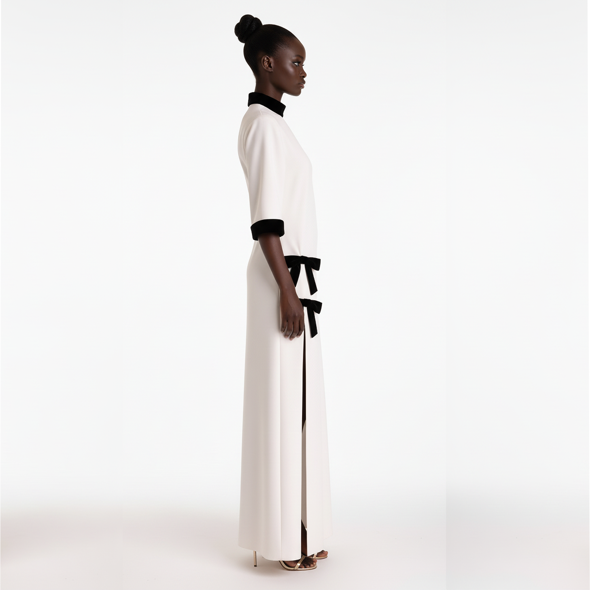 Woman wearing a white dress with black accents on a white background