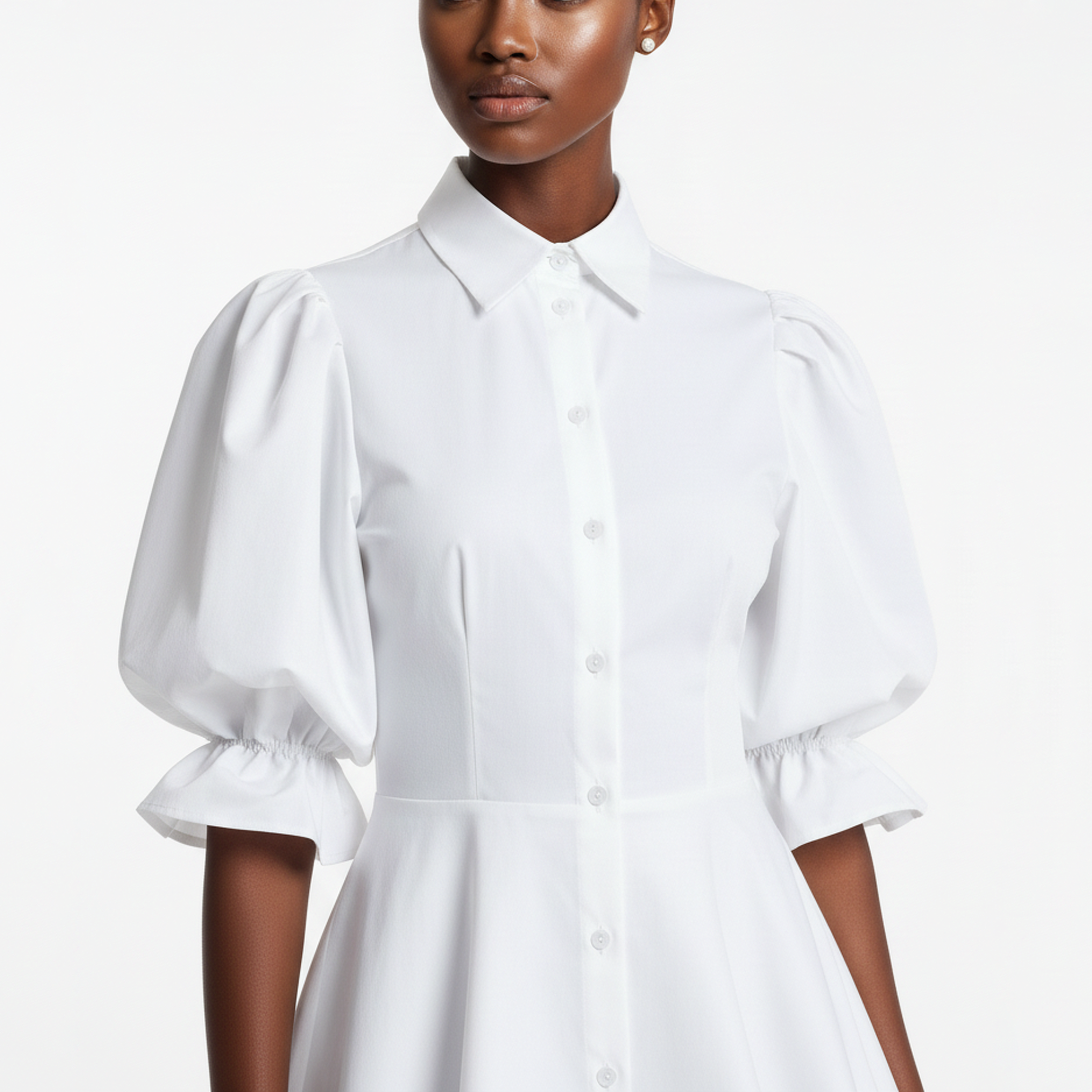 White dress with puff sleeves worn by a model on a white background