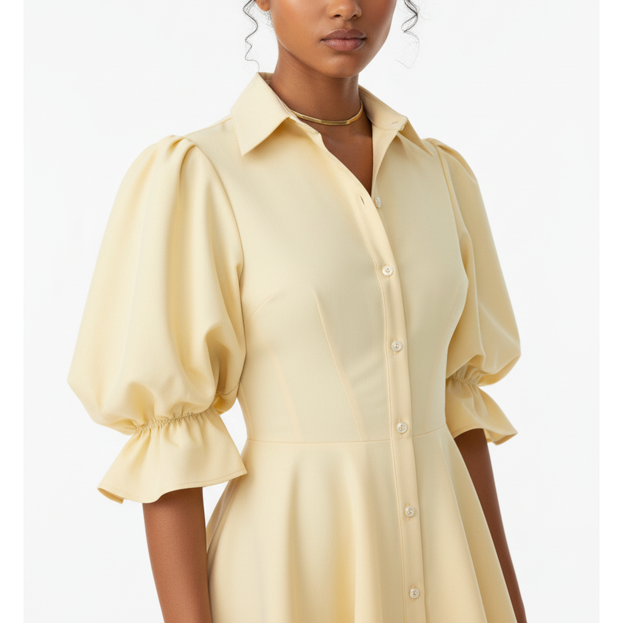 Woman wearing a light yellow dress with puffed sleeves on a white background