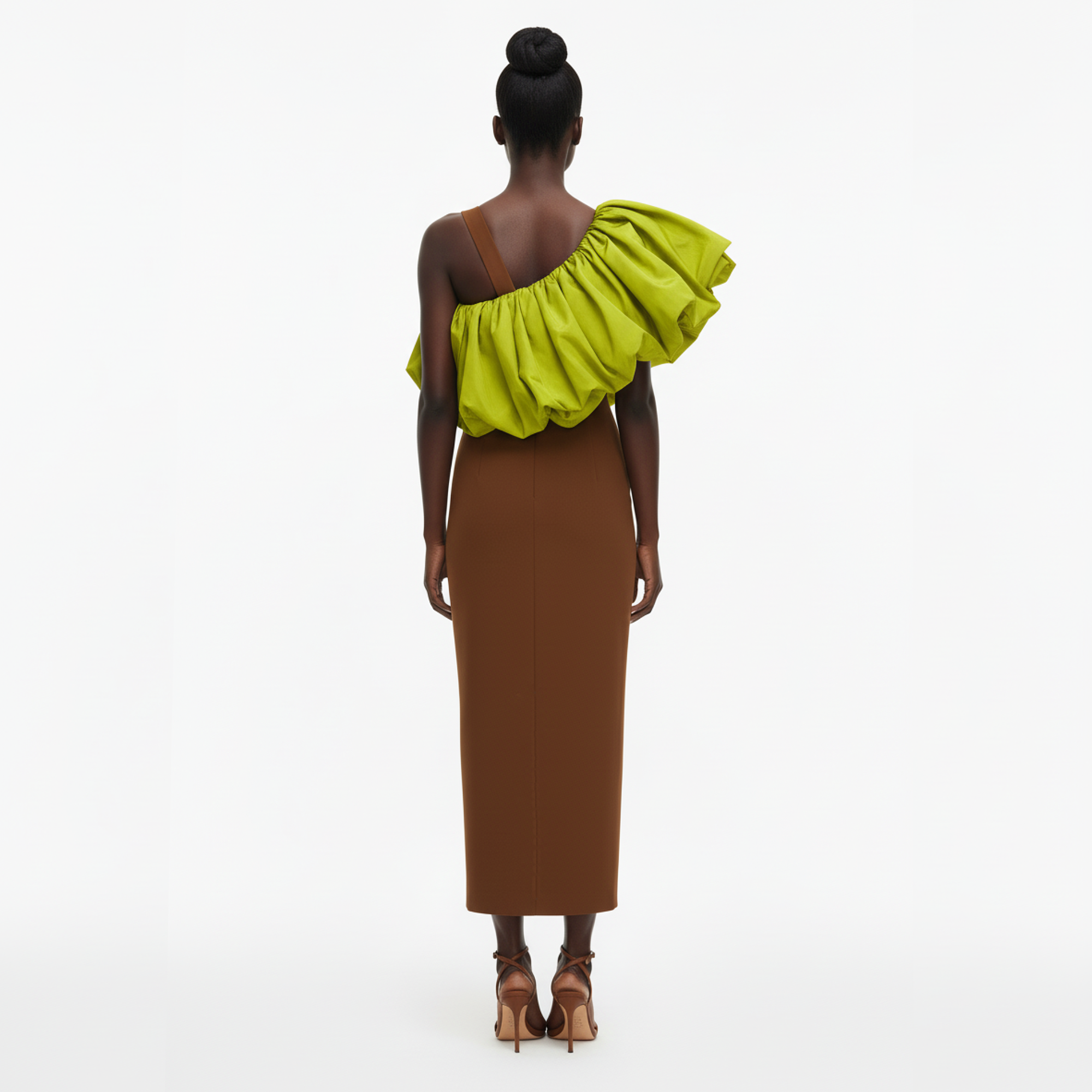 Woman wearing a brown dress with a green ruffled shoulder on a white background