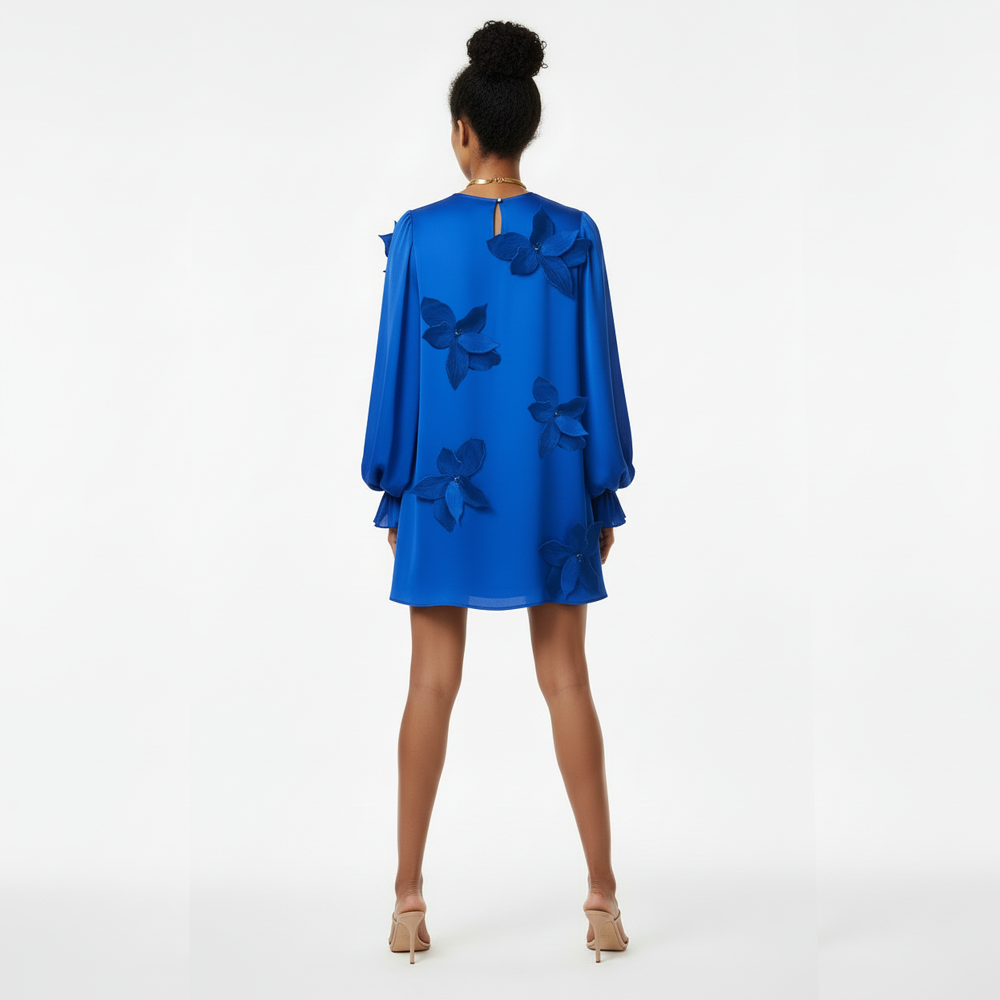 Woman wearing a blue dress with butterfly designs on a white background