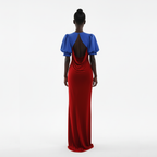 Woman wearing a red and blue dress with an open back on a white background