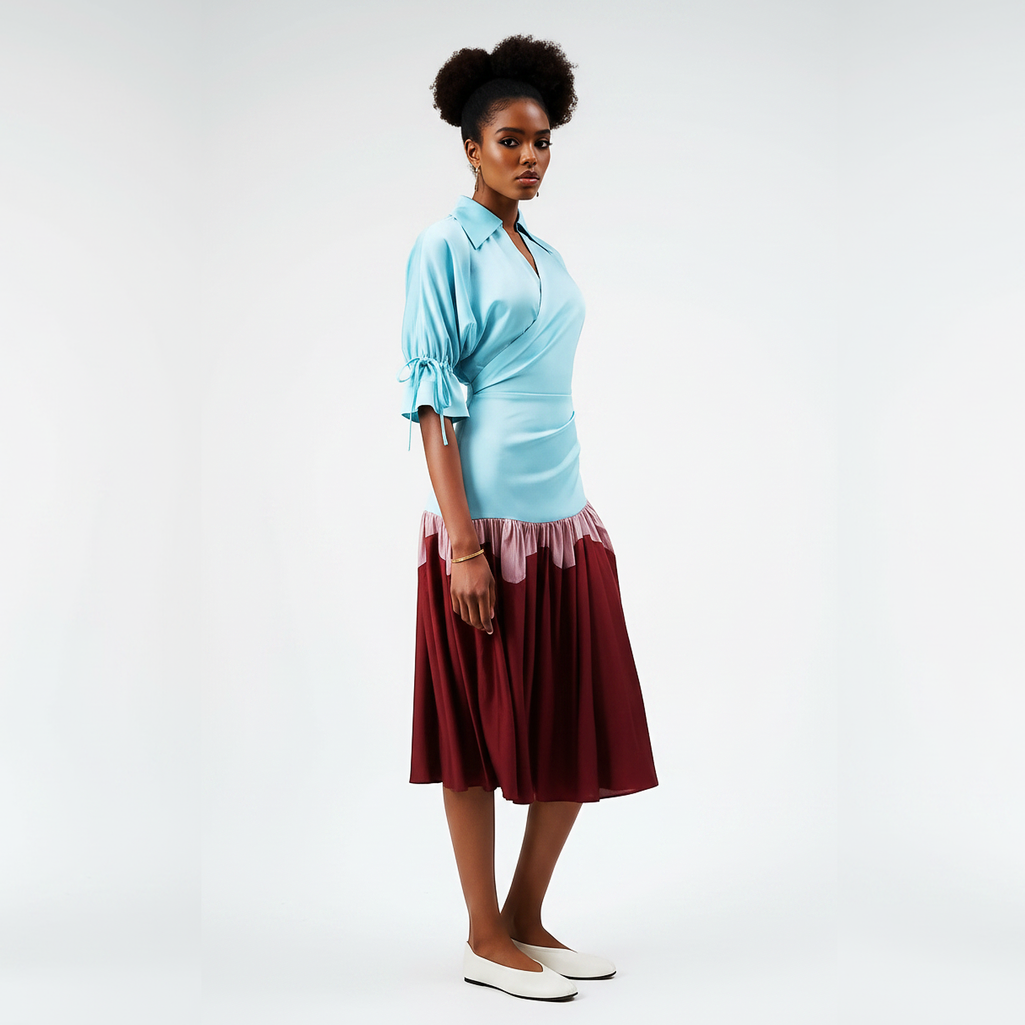 Woman wearing a light blue blouse and maroon skirt on a white background