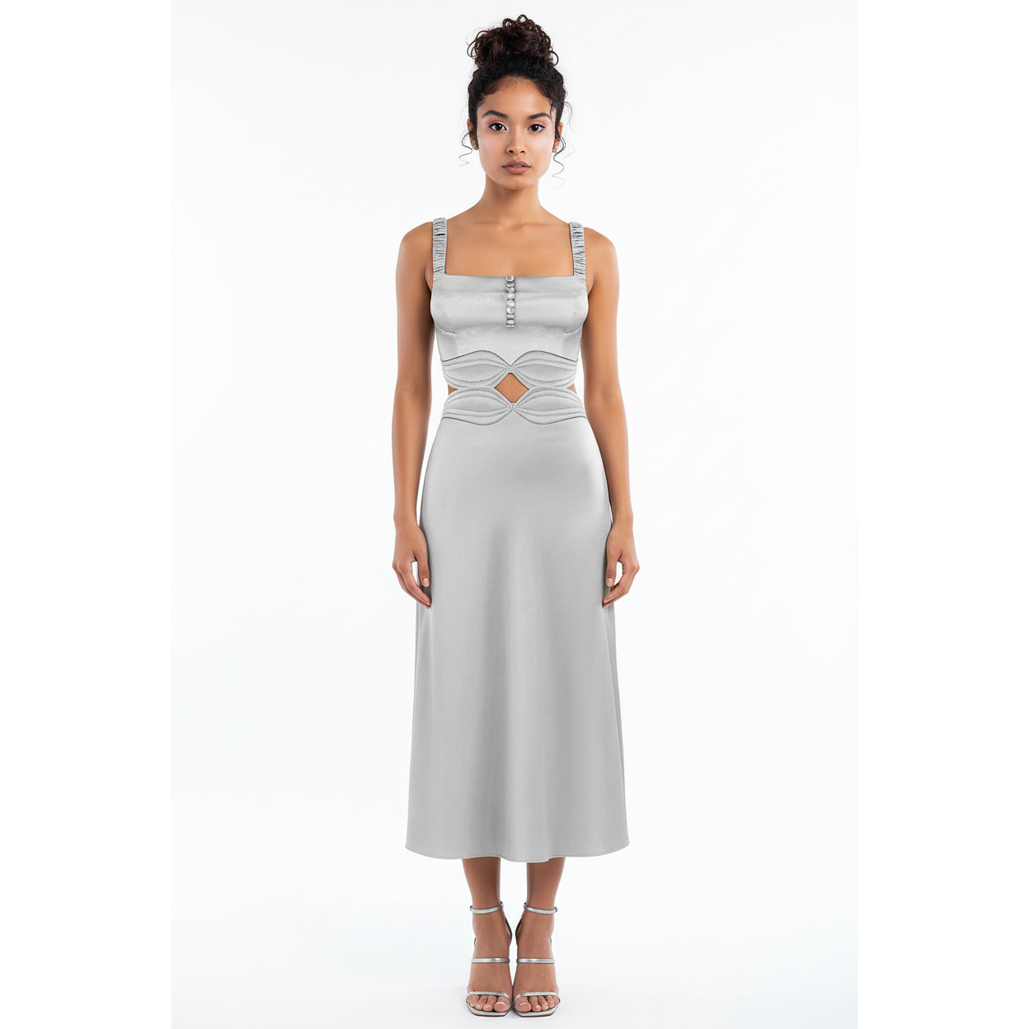 Woman wearing a silver sleeveless dress with a geometric design on a white background