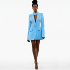 Woman wearing a light blue blazer with embellishments on a white background