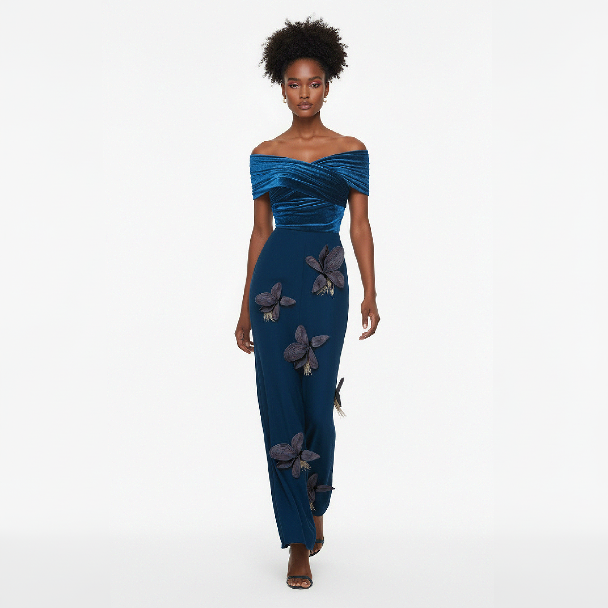Woman wearing a blue off-shoulder gown with floral embellishments on a white background