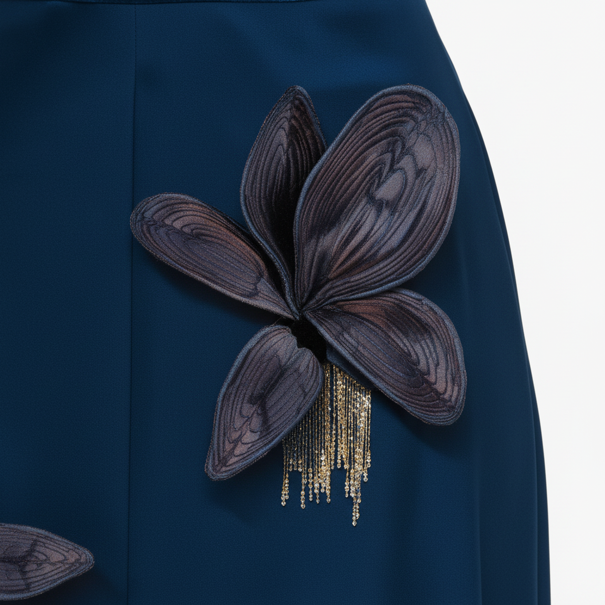 Navy blue fabric with a decorative flower embellishment on a white background